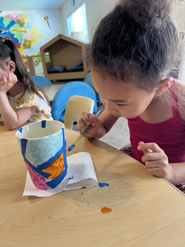 an image of girl painting in a mug